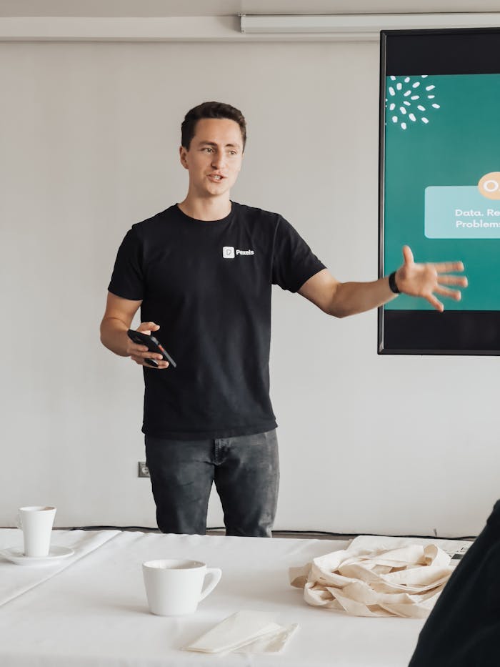 Young man conducting a business presentation in a modern office environment. Engaged and professional.