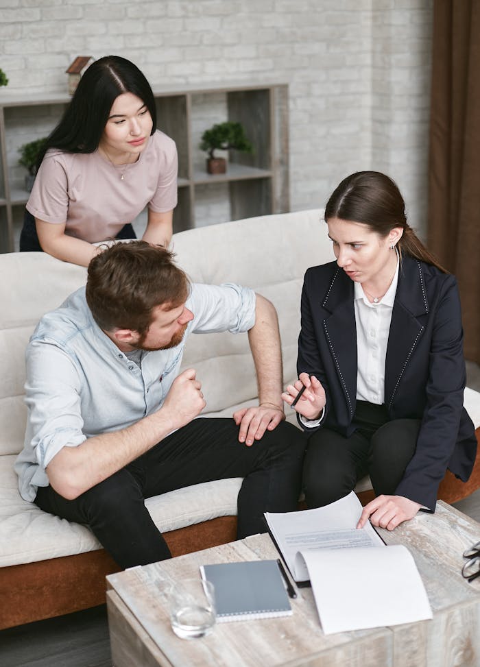 A group of people engaging in a business discussion about contract details in a modern indoor setting.